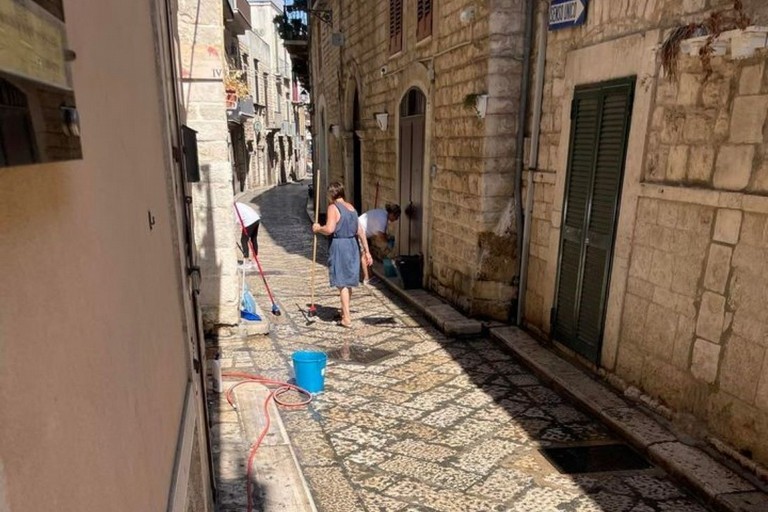 Residenti di via Principe Amedeo lavano la strada